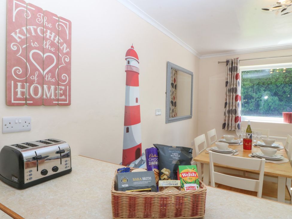 A kitchen with a table set for dining at Salty Puffin in Benllech