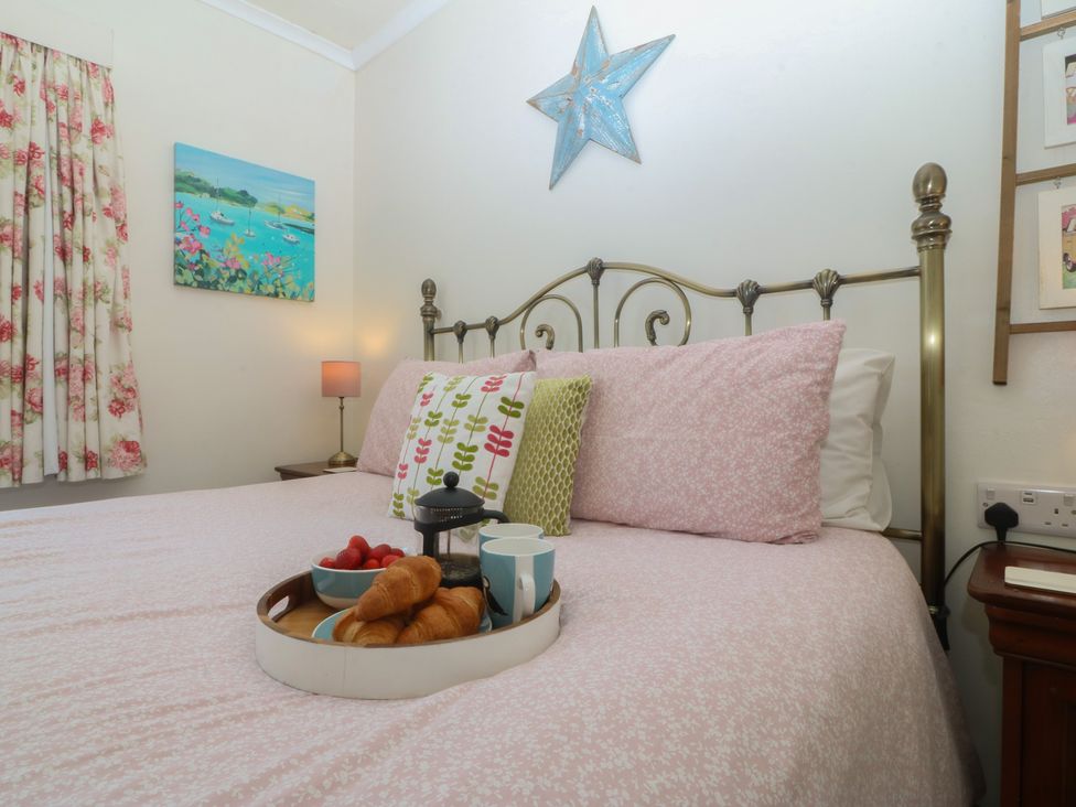 A bedroom with a bed and breakfast tray at Salty Puffin in Benllech
