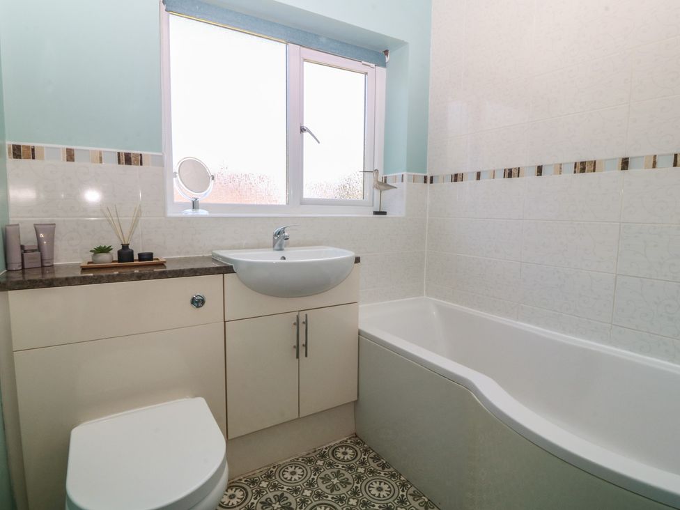 A bathroom with a sink and bathtub at Salty Puffin in Benllech