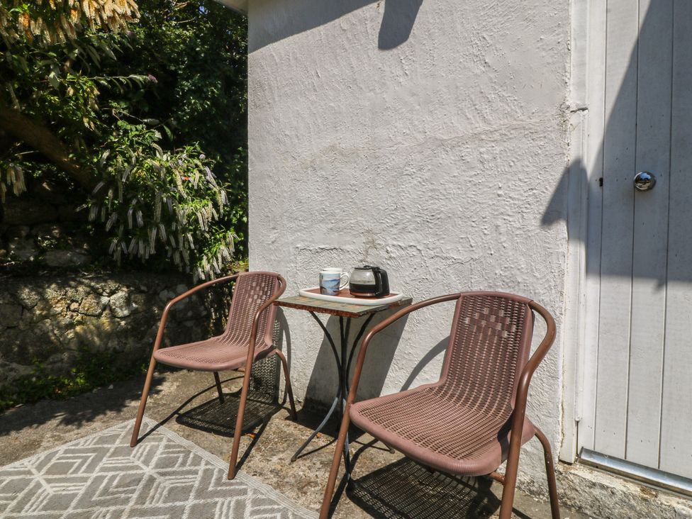 An outdoor area with two chairs and a table at Salty Puffin in Benllech