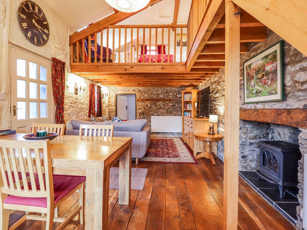 A living room with a dining table and sofa at Dovetail Cottage in Llangollen