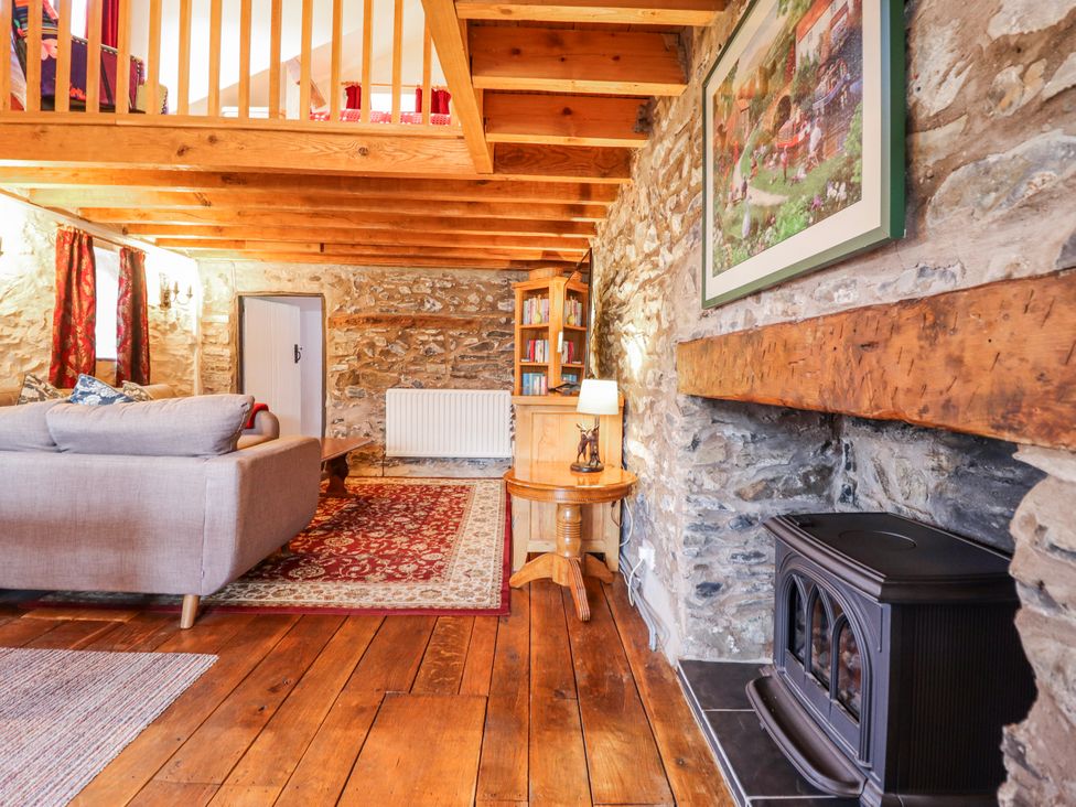 A living room with a sofa and a fireplace at Dovetail Cottage Llangollen