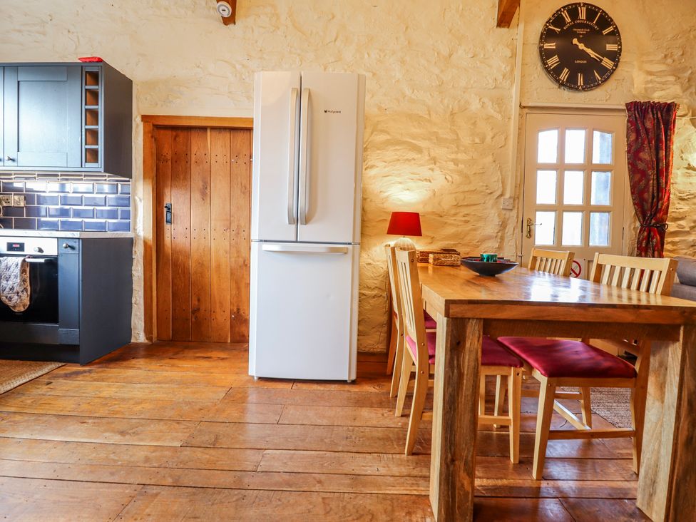 A kitchen with a refrigerator and dining table at Dovetail Cottage Llangollen