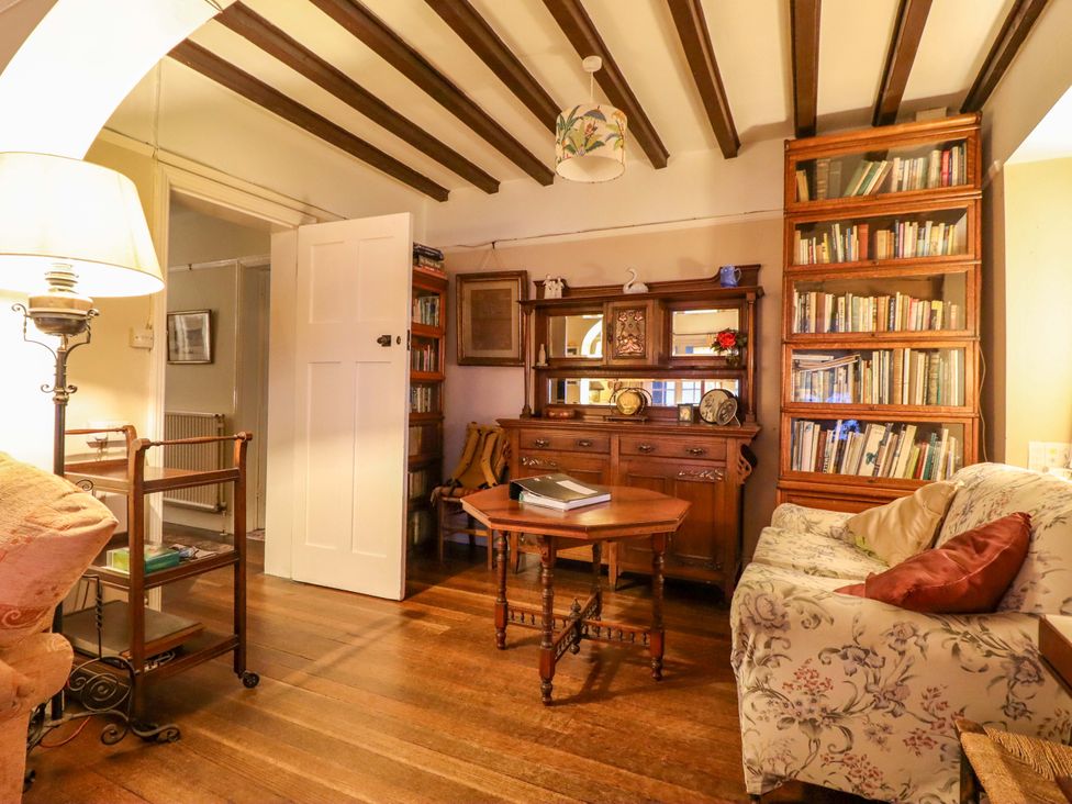 A living room with a sofa and bookshelf at Murmur Y Don in Harlech