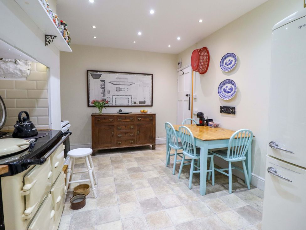 A kitchen with a table and chairs at Murmur Y Don in Harlech