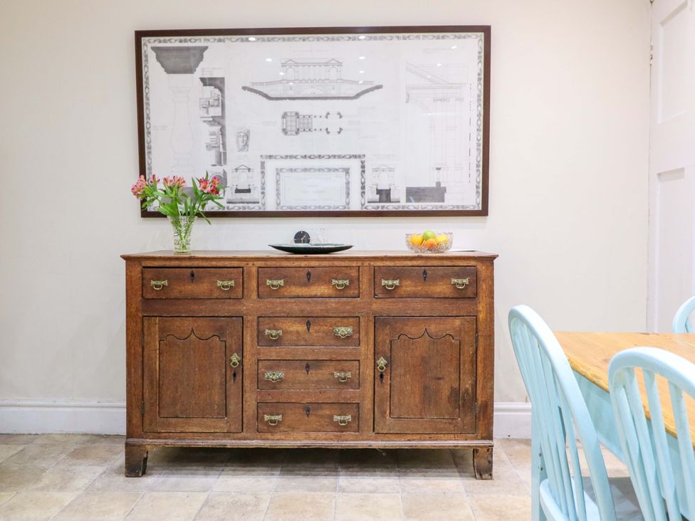 A dining room featuring a sideboard with flowers and fruit bowl at Murmur Y Don in Harlech