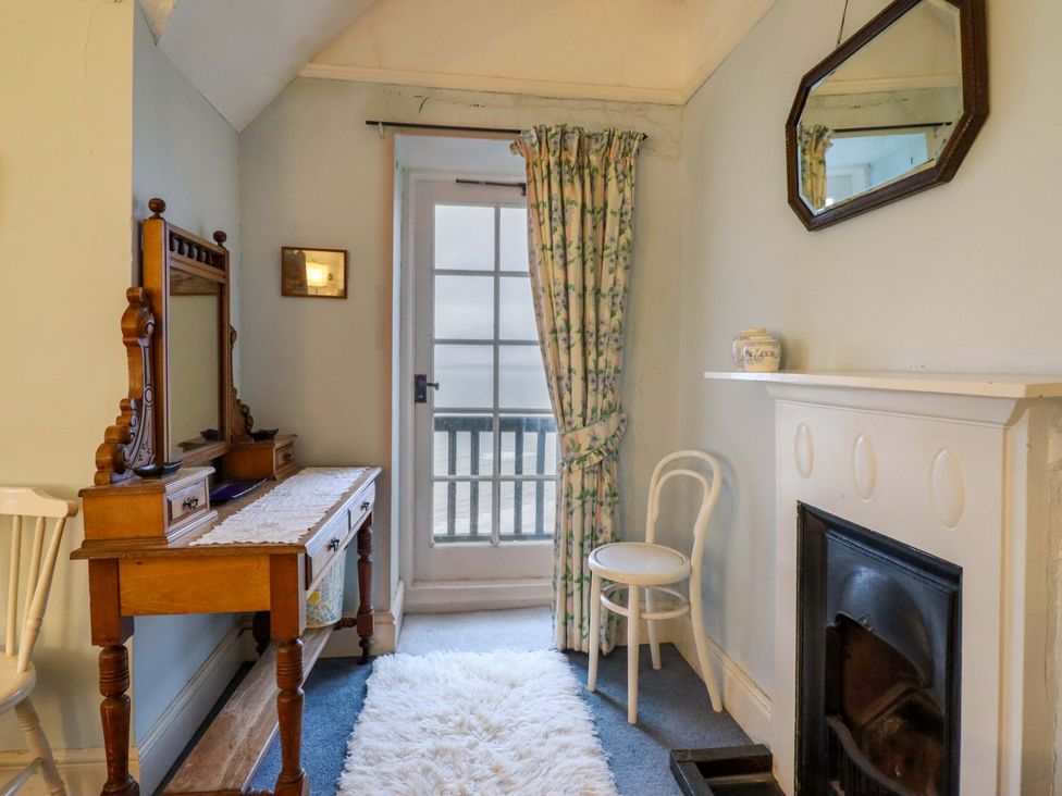 A bedroom with a vanity and a mirror at Murmur Y Don in Harlech