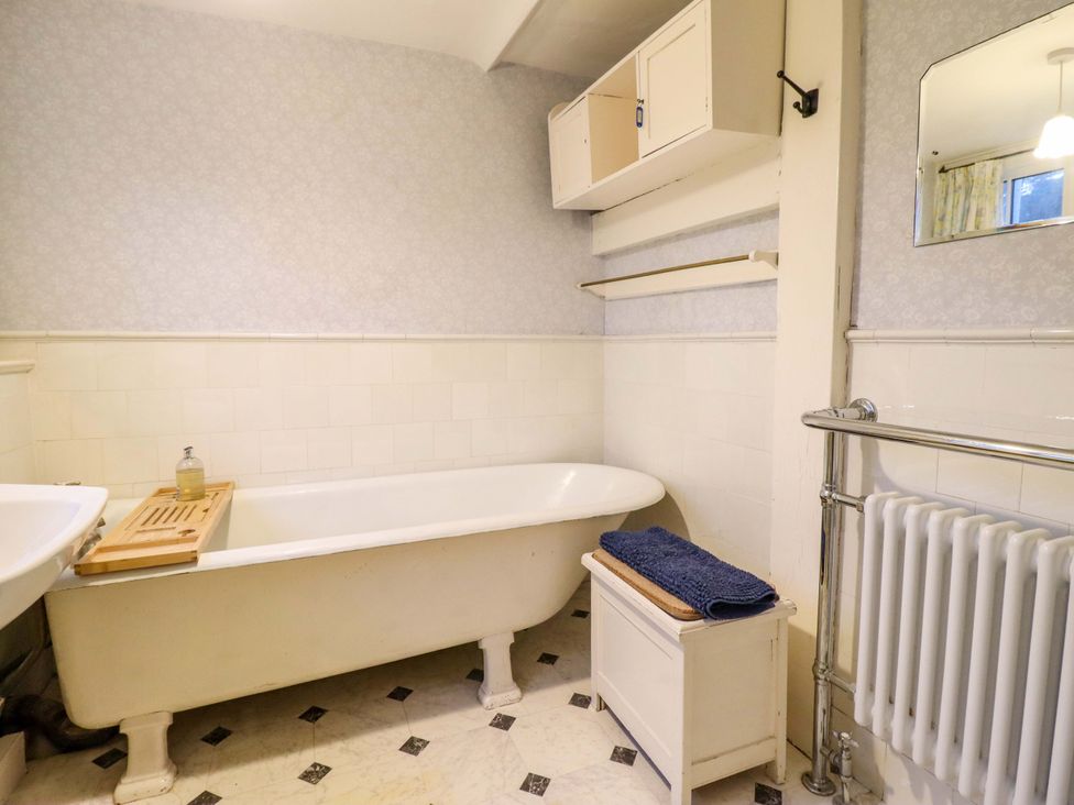 A bathroom with a bathtub and towel at Murmur Y Don in Harlech