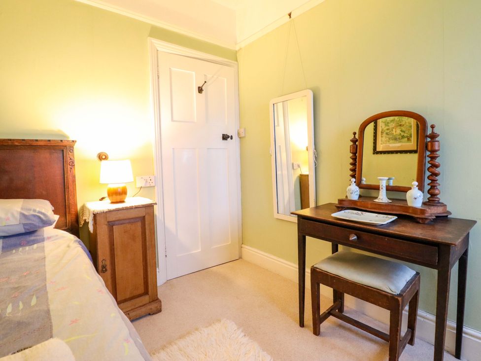 A bedroom with a bed and vanity table at Murmur Y Don, Harlech