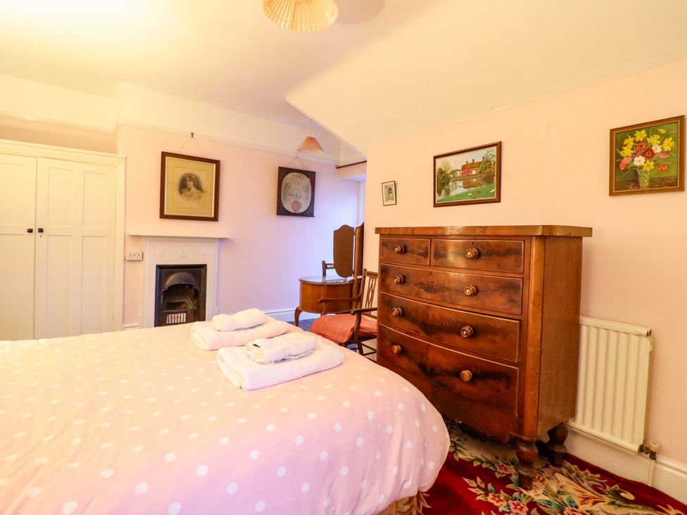 A bedroom with a bed and dresser at Murmur Y Don in Harlech