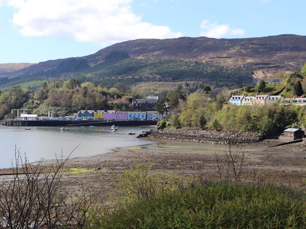A coastal view with colorful buildings and water at MacKenzie’s Peak Sconser near Portree