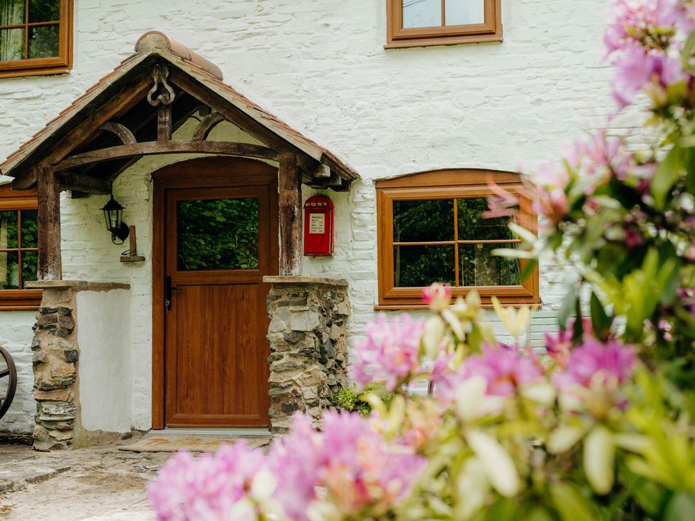An entrance with a wooden door and flowers at The Wilderness in Stiperstones