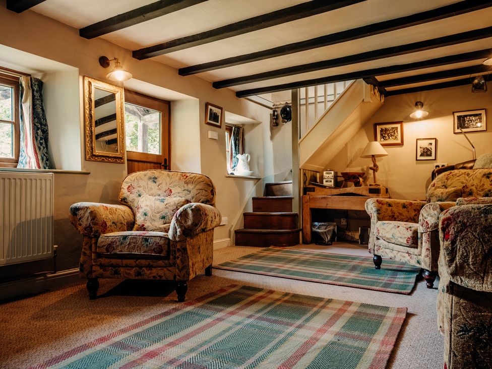 A living room with armchairs and a staircase at The Wilderness in Stiperstones