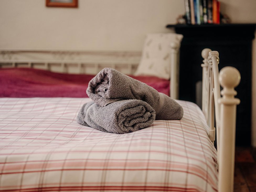 A bed with towels folded on it at The Wilderness in Stiperstones