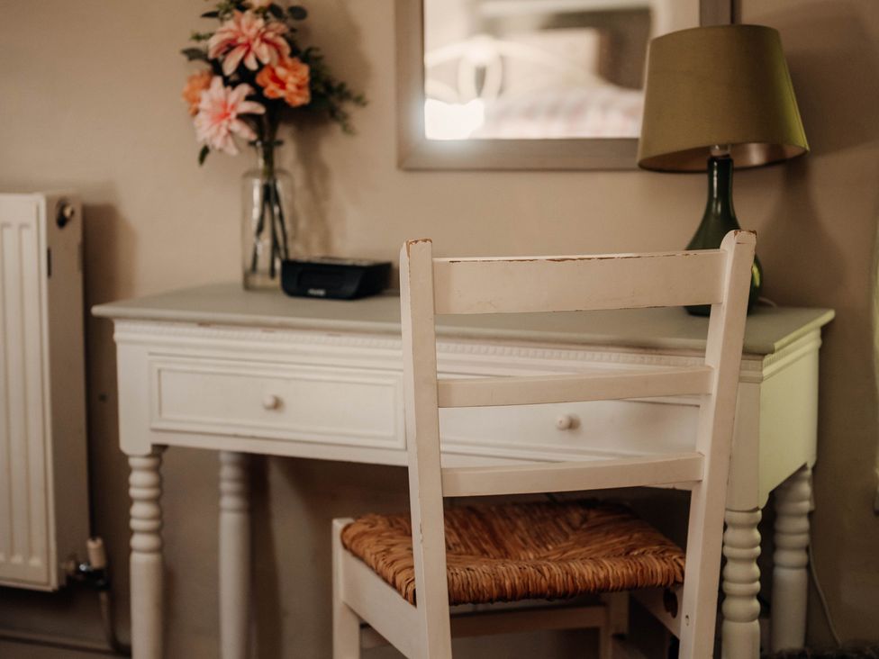 A bedroom with a desk, chair, lamp, and vase at The Wilderness in Stiperstones
