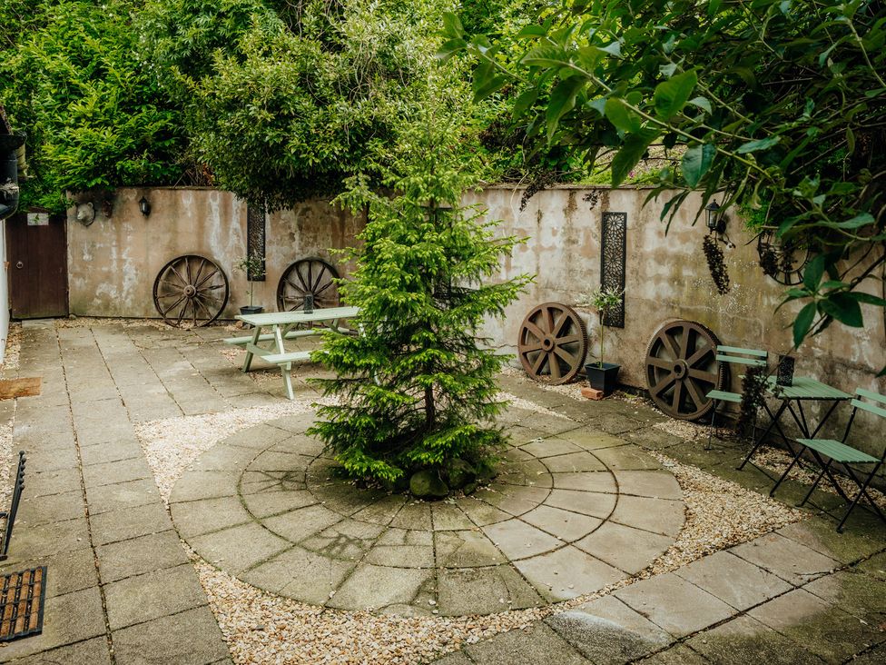 A garden with a tree and seating area at The Wilderness in Stiperstones