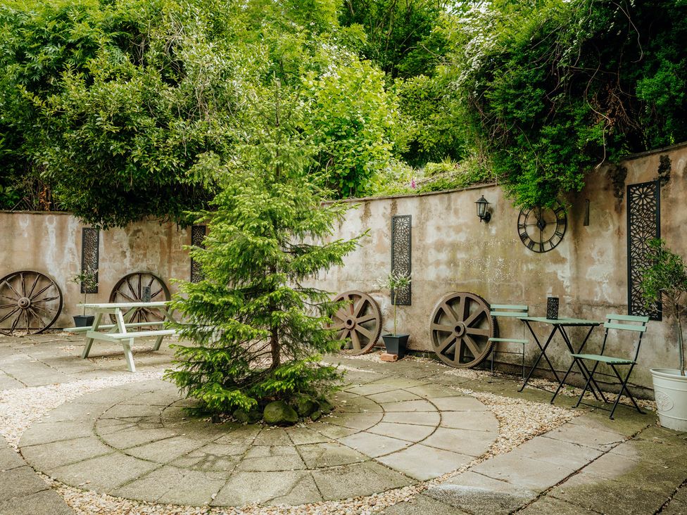 A garden with a stone pathway and seating area at The Wilderness in Stiperstones