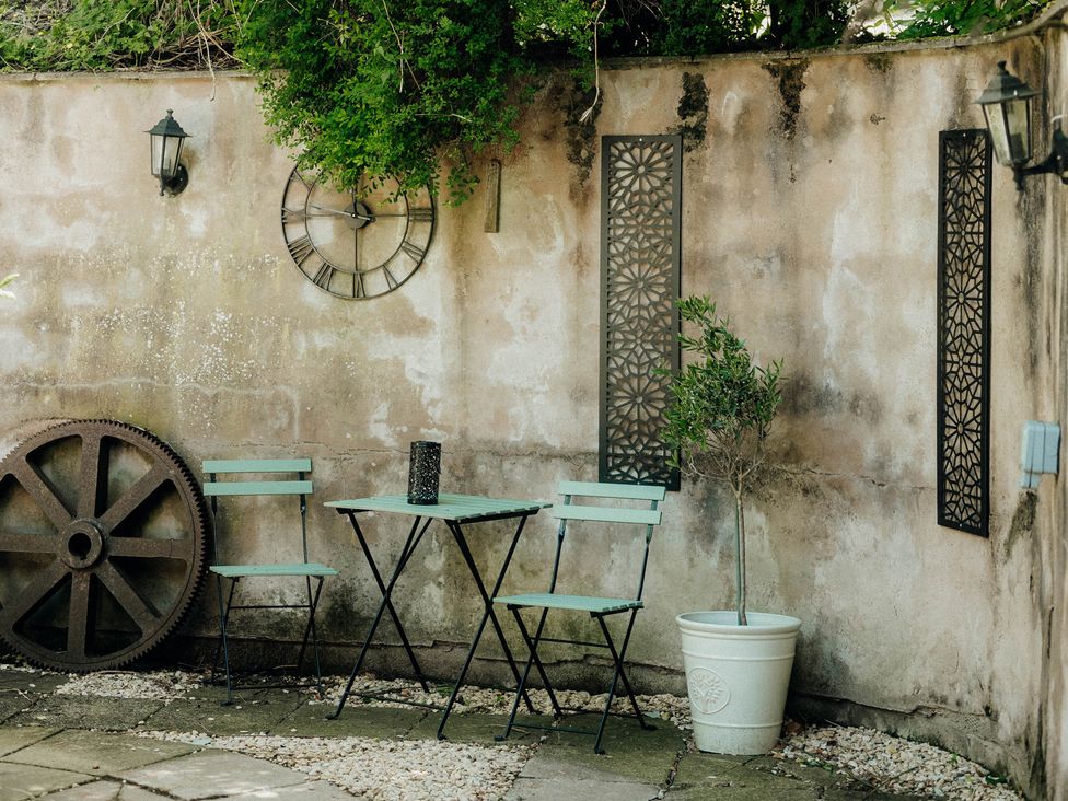 A garden area with a table and metal chairs at The Wilderness Stiperstones