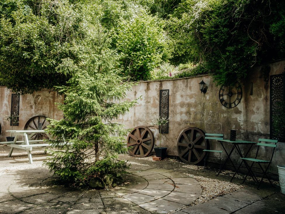 A garden with a tree, table, and chairs at The Wilderness in Stiperstones