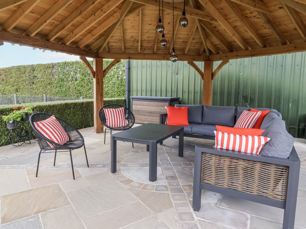 An outdoor seating area with a gazebo and furniture at Pear Tree Cottage in Dunnington