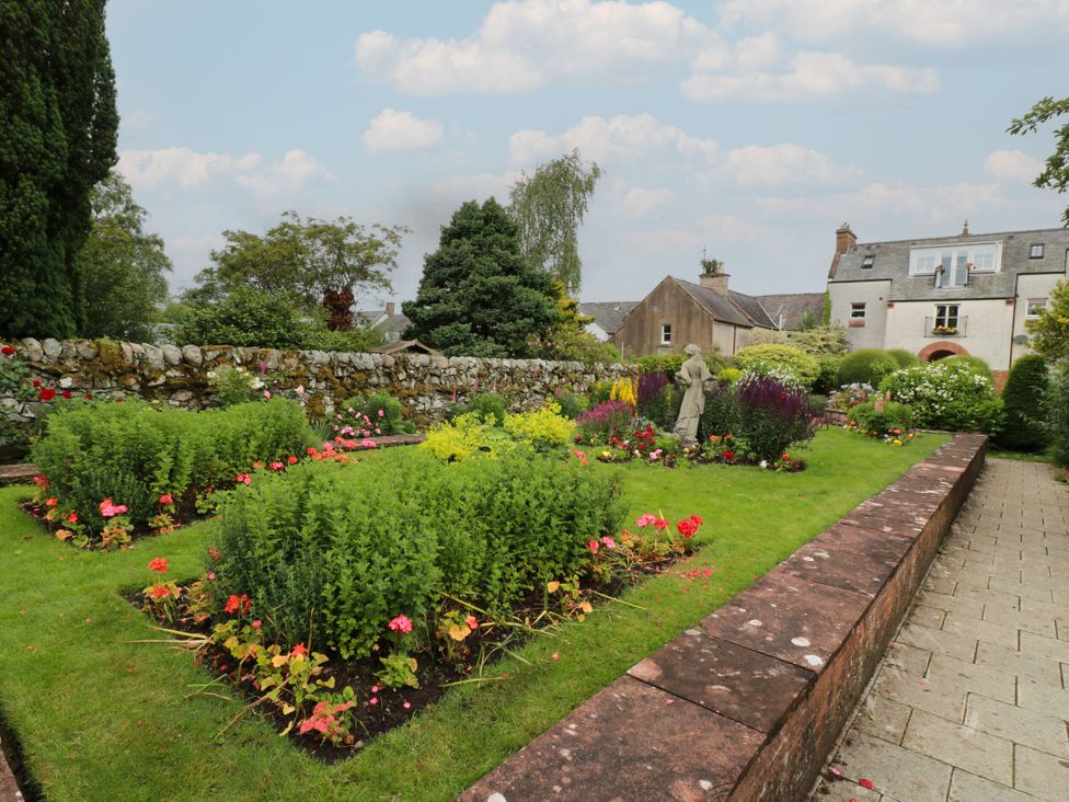 A garden with flowers and a statue at 79 Laurel Bank Gatehouse of Fleet