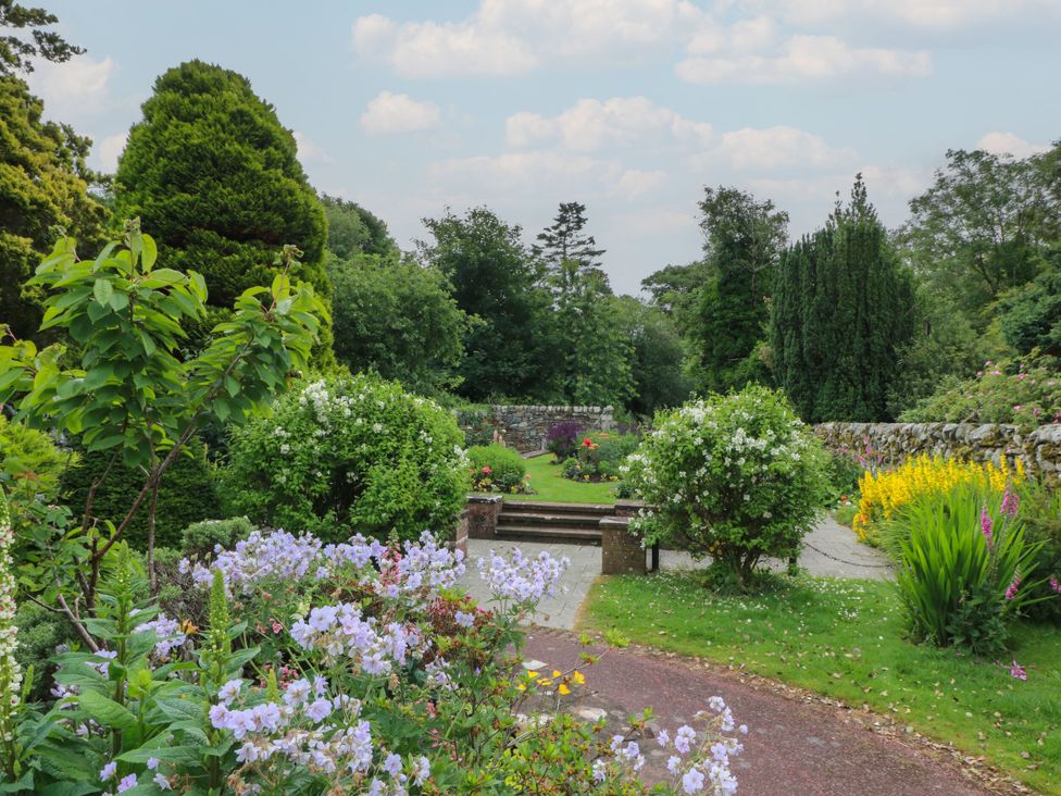 A garden with flowers and a pathway at 79 Laurel Bank in Gatehouse of Fleet