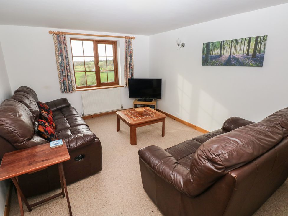 A living room with a sofa, coffee table and television at Bwthyn-y-Rhiw Penybanc near Llandeilo