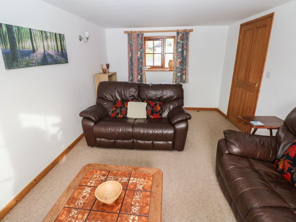 A living room with a sofa and a table at Bwthyn-y-Rhiw in Penybanc near Llandeilo