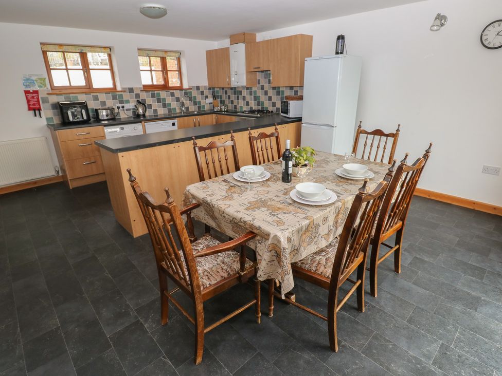 A kitchen with a dining table and chairs at Bwthyn-y-Rhiw in Penybanc near Llandeilo