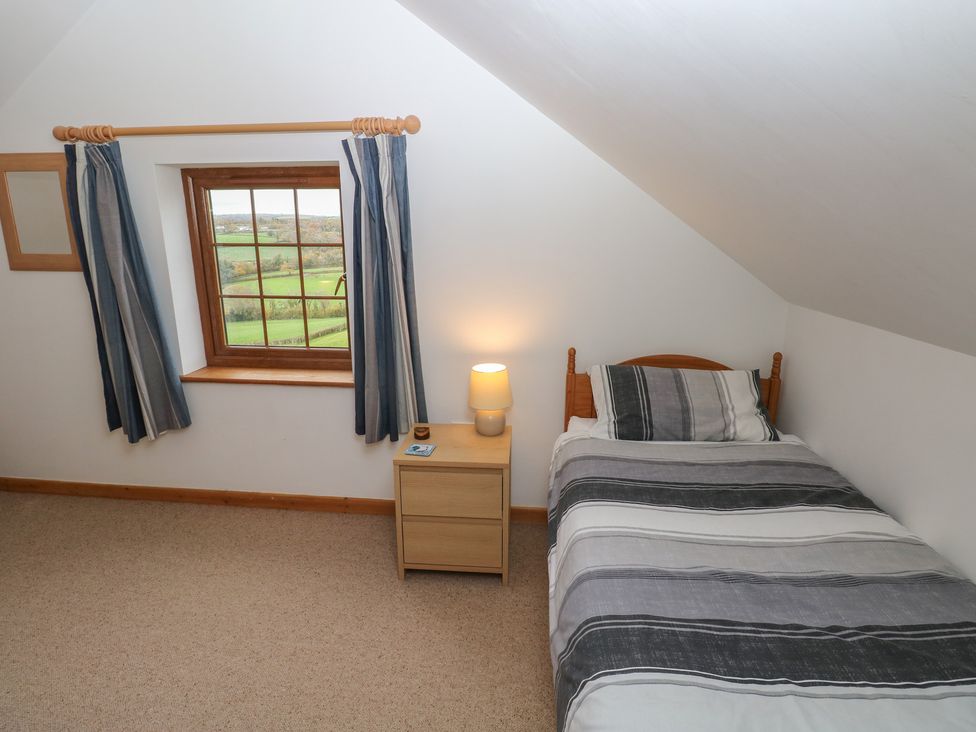 A bedroom with a single bed and a window at Bwthyn-y-Rhiw in Penybanc near Llandeilo