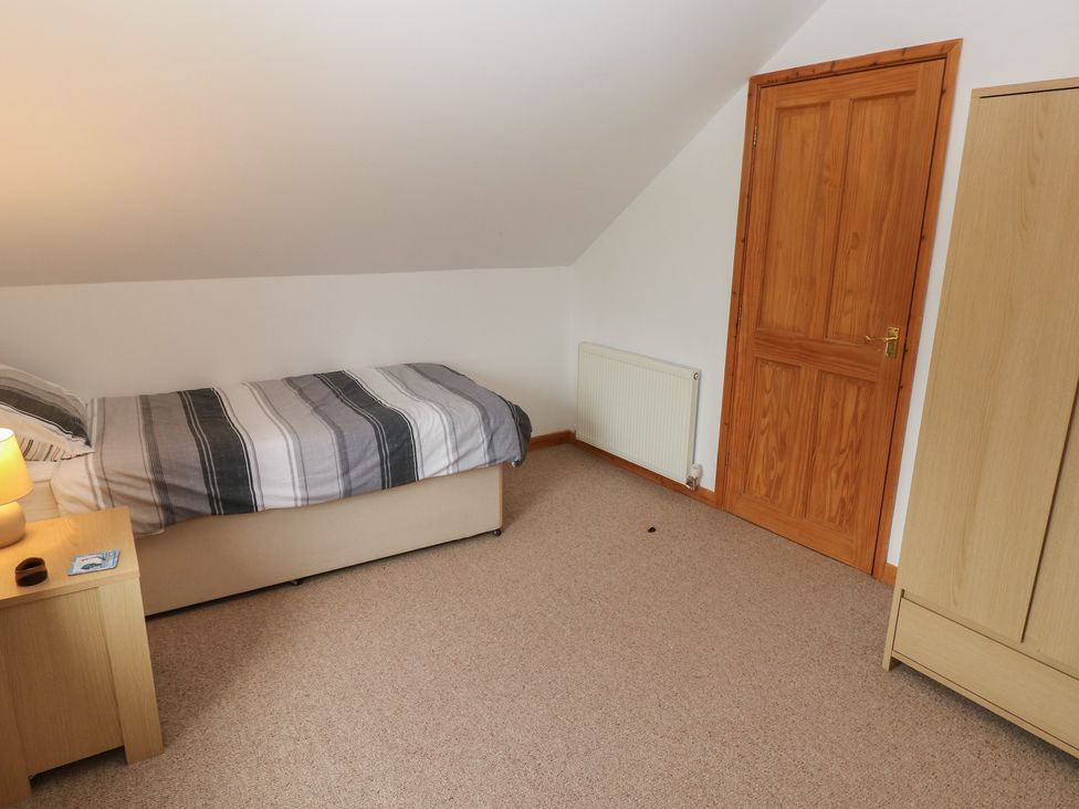 A bedroom with a bed and wardrobe at Bwthyn-y-Rhiw Penybanc near Llandeilo