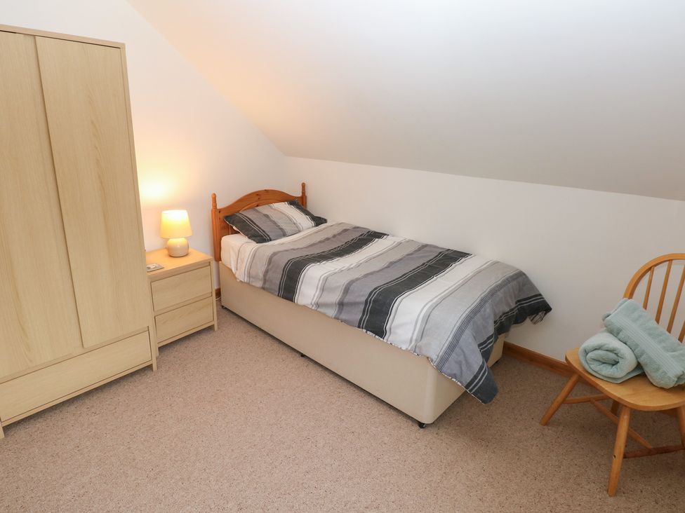 A bedroom with a single bed and furniture at Bwthyn-y-Rhiw near Penybanc Llandeilo
