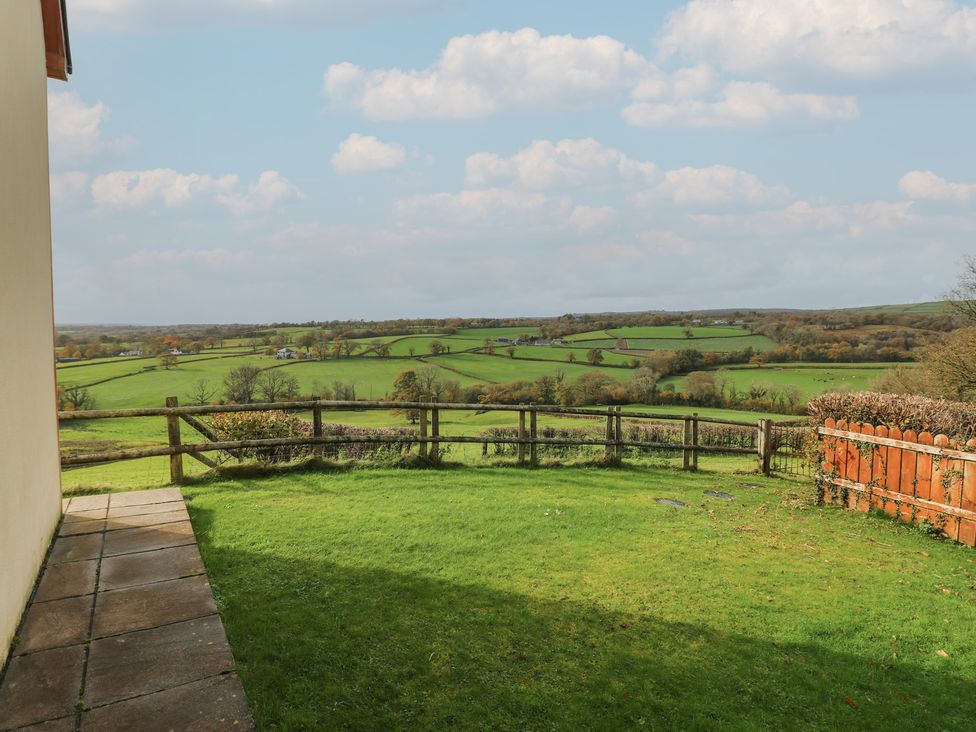 A garden view with rolling fields and a fence at Bwthyn-y-Rhiw Penybanc near Llandeilo