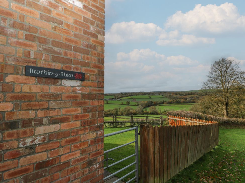 A brick wall with a sign and a view of the landscape at Bwthyn-y-Rhiw Penybanc near Llandeilo