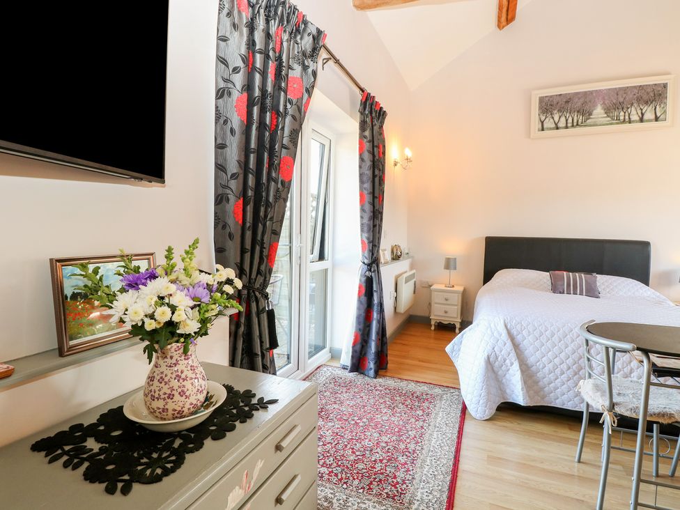 A bedroom with a bed and decorative furnishings at Snowy Owl Barn Shipdham