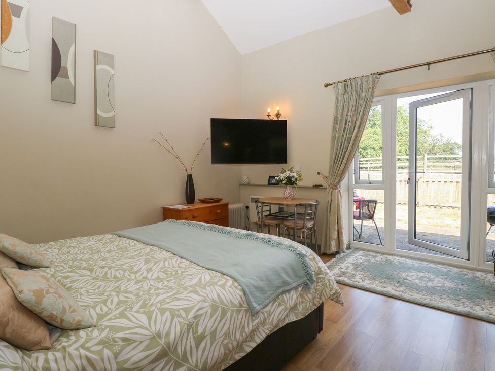 A bedroom with a bed and table at Tawny Owl Barn Shipdham near Dereham