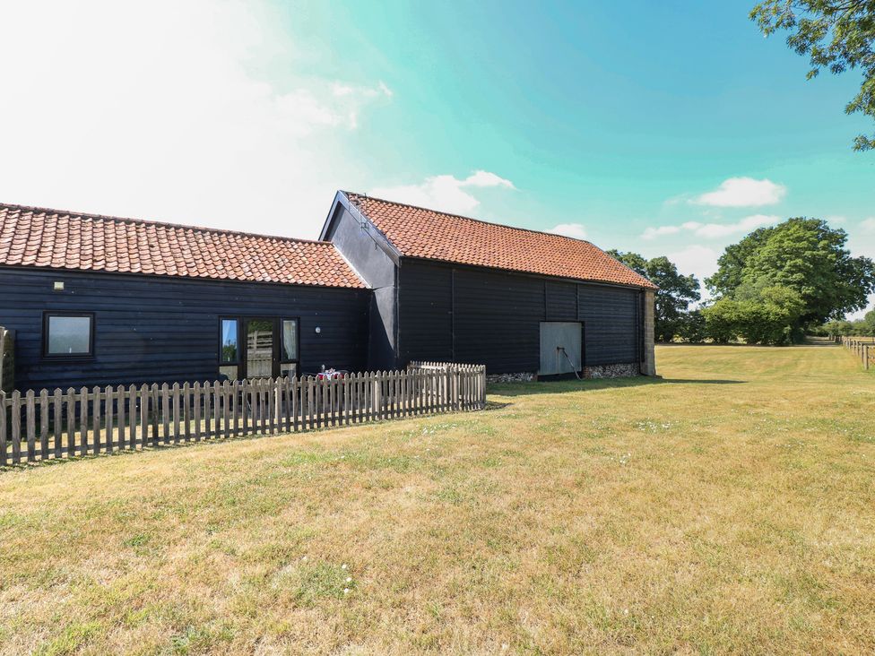 A barn with a fence and grass at Tawny Owl Barn Shipdham near Dereham