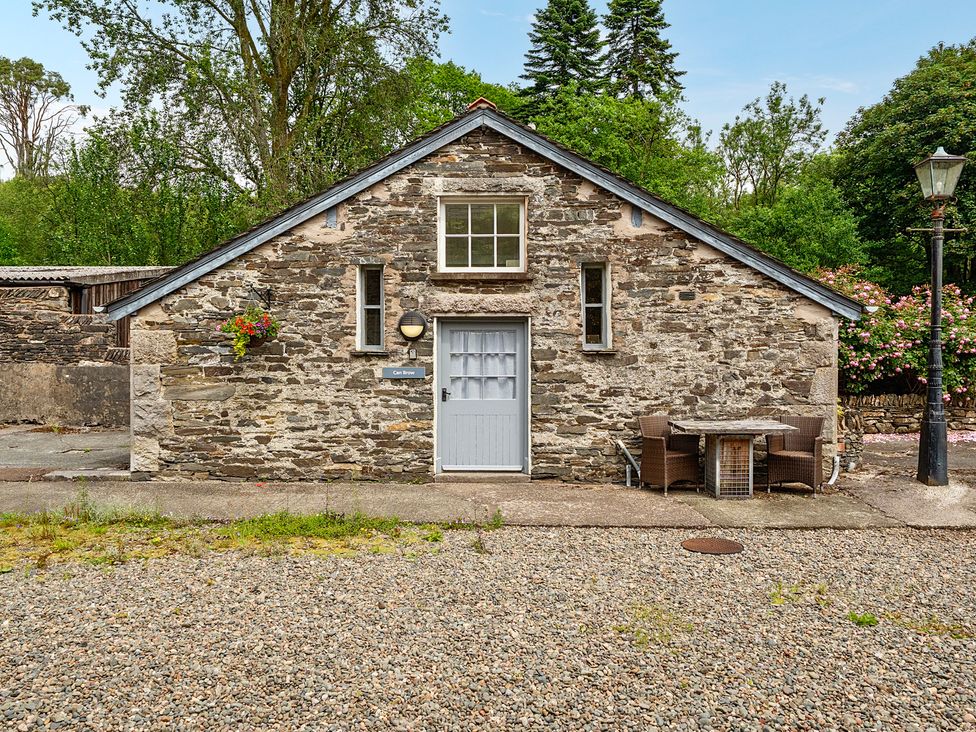A stone building with a table and chairs at Can Brow at the Graythwaite Estate near Hawkshead