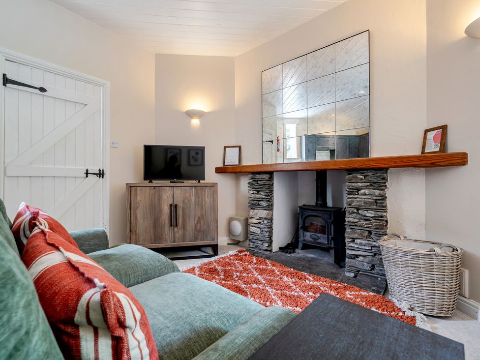 A living room with a sofa and television at Can Brow at the Graythwaite Estate near Hawkshead
