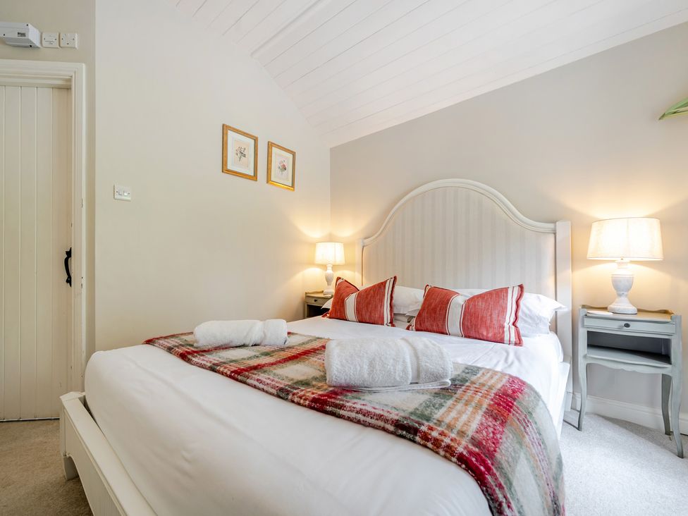 A bedroom with a bed and bedside table at Can Brow at the Graythwaite Estate near Hawkshead