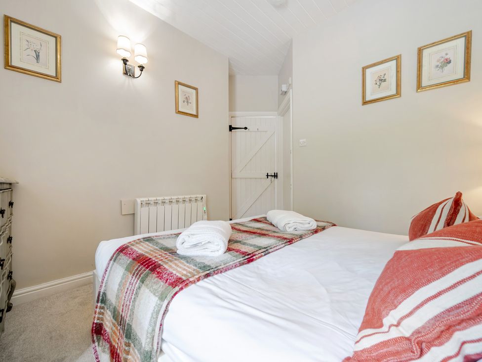 A bedroom with a bed and wall art at Can Brow at the Graythwaite Estate near Hawkshead