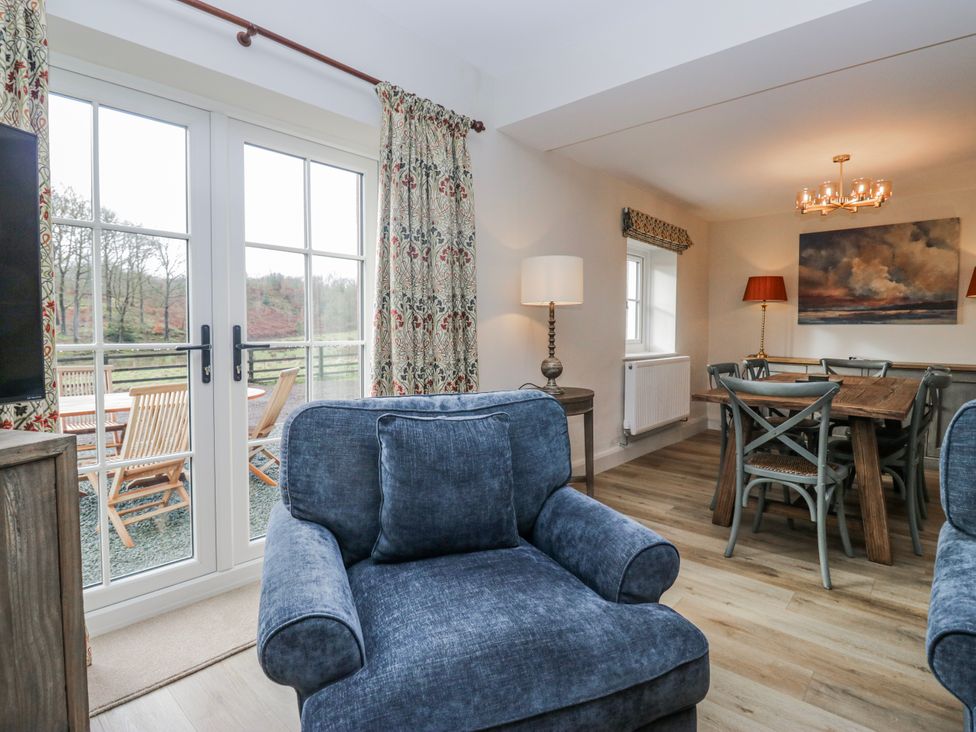 A living room with a sofa and dining area at Jubilee in Graythwaite near Hawkshead