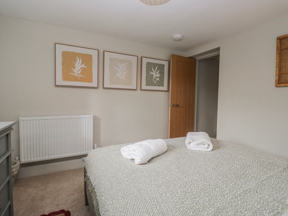 A bedroom with a bed and towels on it at Jubilee in Graythwaite near Hawkshead