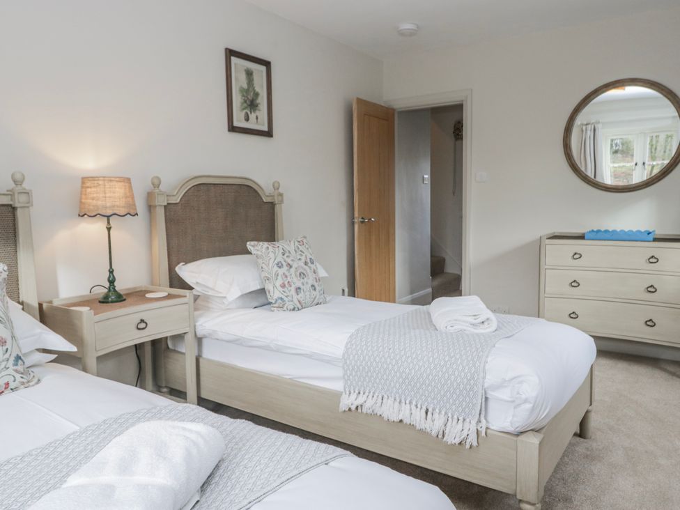 A bedroom with two beds and a dresser at Jubilee in Graythwaite near Hawkshead