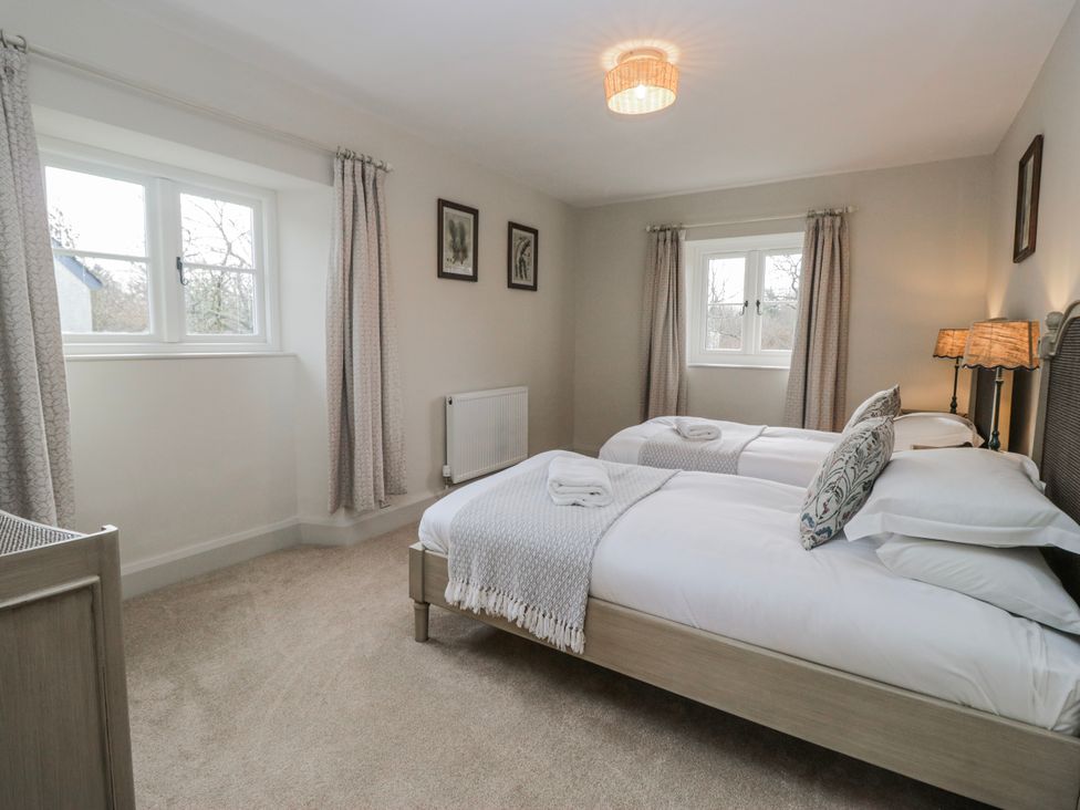 A bedroom with two single beds and a window at Jubilee in Graythwaite near Hawkshead