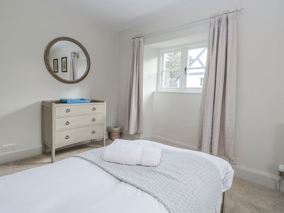 A bedroom with a dresser and mirror at Jubilee in Graythwaite near Hawkshead