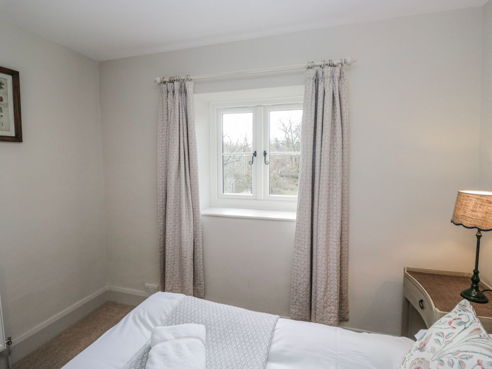 A bedroom with a bed and window at Jubilee in Graythwaite near Hawkshead