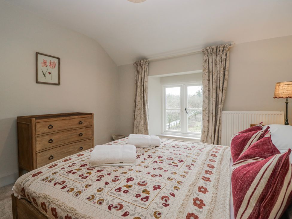 A bedroom with a bed and dresser at Jubilee in Graythwaite near Hawkshead