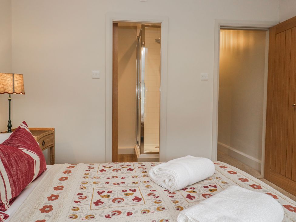 A bedroom with a bed and towels at Jubilee in Graythwaite near Hawkshead