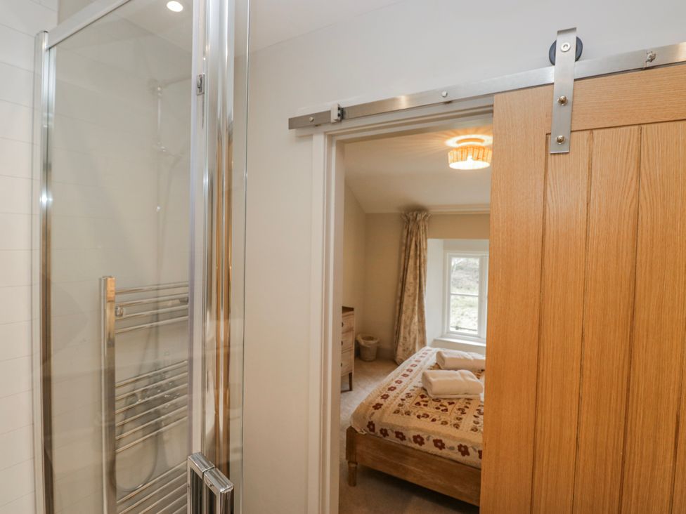 A bathroom with a shower and an open door leading to a bedroom at Jubilee in Graythwaite near Hawkshead